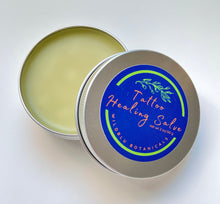 Load image into Gallery viewer, an open tin showing contents of the tattoo healing salve a light yellow salve and nearby lid
